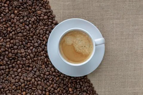 Coffee cup with burlap sack of roasted beans Stock Photos