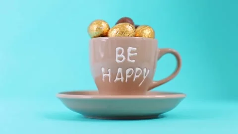 Coffee cup with chocolate eggs on a blue background. Stock Footage 339283269