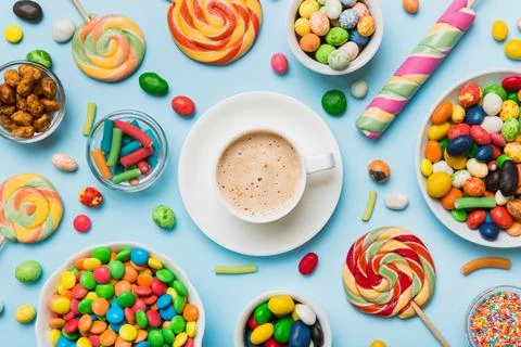 Coffee cup with chocolates and colored candy. Top view on table background .. Stock Photos