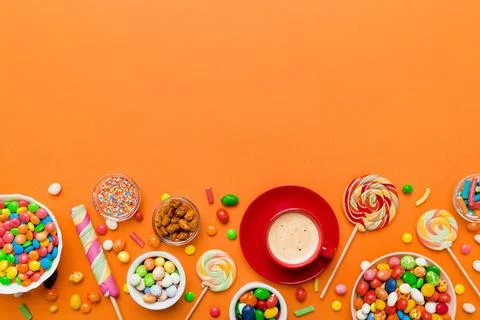 Coffee cup with chocolates and colored candy. Top view on table background .. Stock Photos