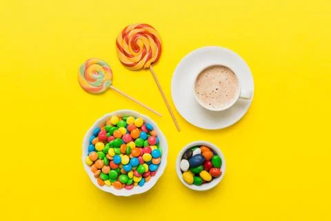 Coffee cup with chocolates and colored candy. Top view on table background .. Stock Photos