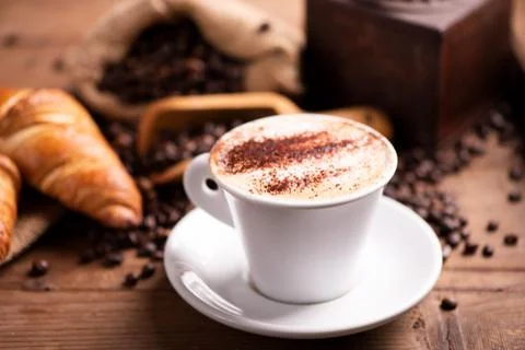 Coffee cup close-up over dark roasted coffee beans Stock Photos