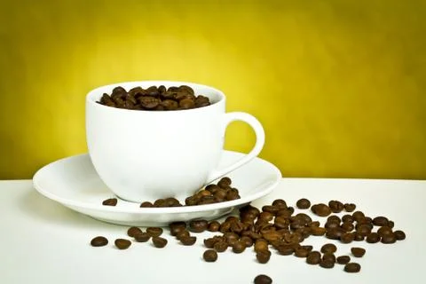 Coffee cup with coffee bean on table Stock Photos