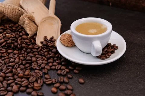 Coffee cup with coffee beans in background on dark background Stock Photos