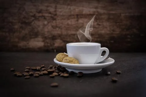 Coffee cup with coffee beans in background on dark background Photos