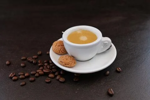 Coffee cup with coffee beans in background on dark background Stock Photos