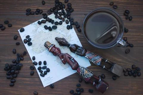 Coffee Cup, coffee beans, map of Africa and wooden statues. the concept of .. Stock Photos
