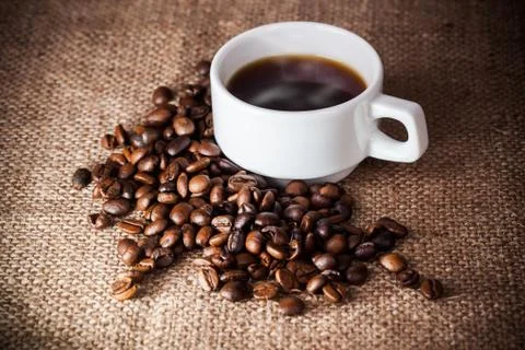 Coffee cup on coffee beans Stock Photos
