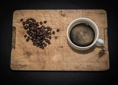 Coffee cup with coffee beans on a rustic wooden background Stock Photos