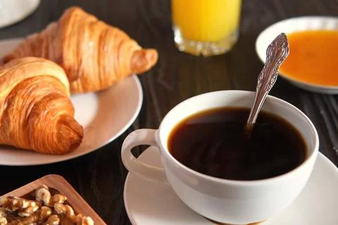 Coffee cup with croissant on a rustic dark wooden table. Food series. Two tasty Stock Photos