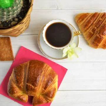 A coffee cup with espresso, croissants, biscuits, cactus in the basket Stock Photos