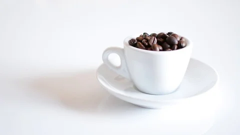 Coffee cup full of roasted coffee beans and white background focusing Video stock 95397175