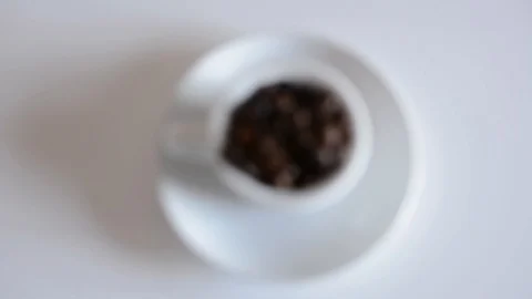 Coffee cup full of roasted coffee beans and white background focusing Video stock 95397177
