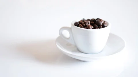 Coffee cup full of roasted coffee beans and white background focusing Video stock 95397181