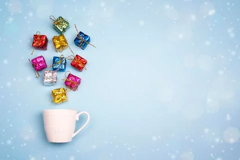 Coffee cup with gift boxes coming out of it  on blue background. Space for th Stock Photos
