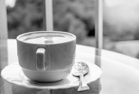 Coffee in a cup on a glass table, side view, breakfast on the balcony, black and Stock Photos
