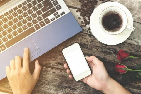 Coffee cup with hand using laptop and Mobile phone on old wood background Stock Photos