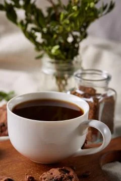 Coffee cup, jar with coffee beans, cookies over rustic background, selective Stock Photos