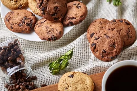 Coffee cup, jar with coffee beans, cookies over rustic background, selective Stock Photos
