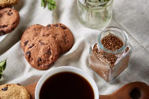 Coffee cup, jar with coffee beans, cookies over rustic background, selective Stock Photos