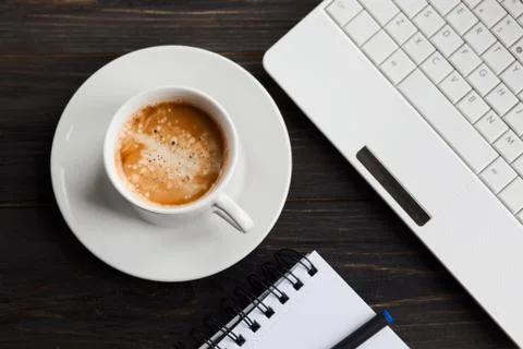 Coffee cup, laptop and notepad on wooden table. Top view Stock Photos