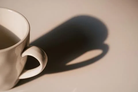 Coffee cup with long shadow side view Stock Photos