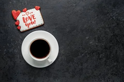 Coffee cup with love note on dark surface Stock Photos