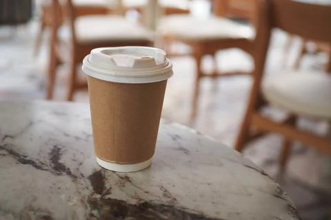 Coffee cup on a marble table in a cafe setting during daytime Stock Photos