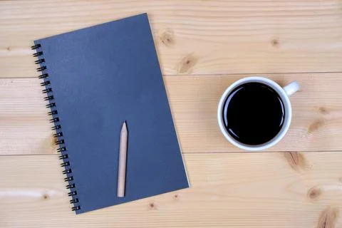 Coffee cup with note book on table Stock Photos
