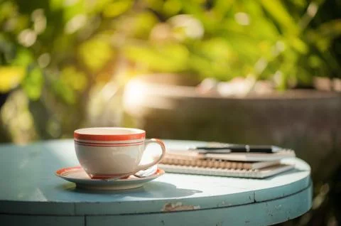 Coffee cup with notebook on cafe table Stock Photos