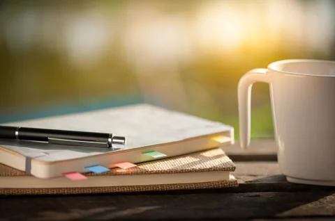 Coffee cup with notebook on rustic wood table Stock Photos