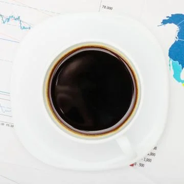 Coffee cup over world map and financial documents - view from top 写真素材