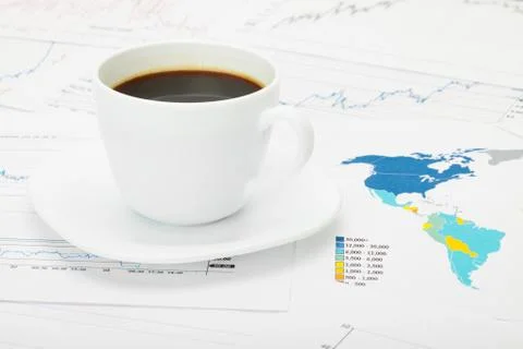 Coffee cup over world map and financial documents Fotos de archivo