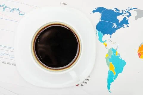 Coffee cup over world map and financial documents - view from top Foto stock