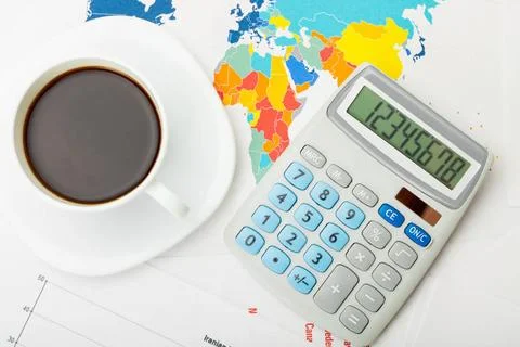  Coffee cup over world map and financial documents - view from top Coffee ... Stock Photos
