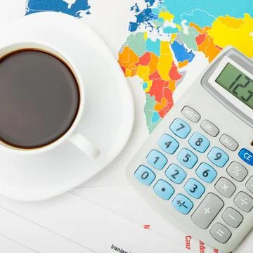  Coffee cup over world map and financial documents - view from top Coffee ... Fotos Stock