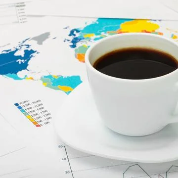 Coffee cup over world map and some financial documents Coffee cup over wor... Stock Photos