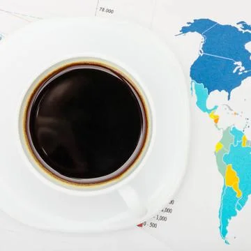 Coffee cup over world map and financial documents - view from top Coffee c... 写真素材