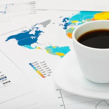 Coffee cup over world map and some financial documents Coffee cup over wor... Stock Photos