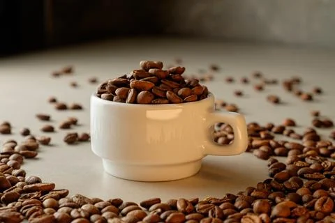Coffee cup overflowing with roasted beans creates a cozy atmosphere Stock Photos