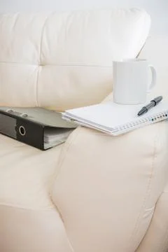 Coffee cup, pen, notebook  ,document file is on white sofa Stock Photos