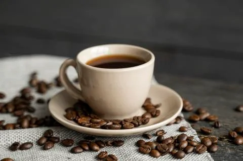 Coffee cup with roasted coffee beans on wooden table background. Mug of black Stock Photos