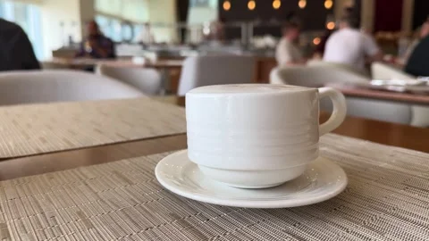 Coffee cup on saucer rests on table, surrounded by wood furniture Stock Footage 274418787