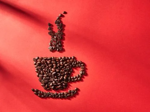 Coffee cup shape made with coffee beans idea, on red background.. Foto stock