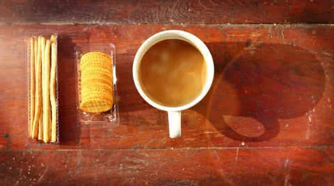 Coffee cup with smoke and cracker on wood. Light ray effect.  Stock Footage 61165082