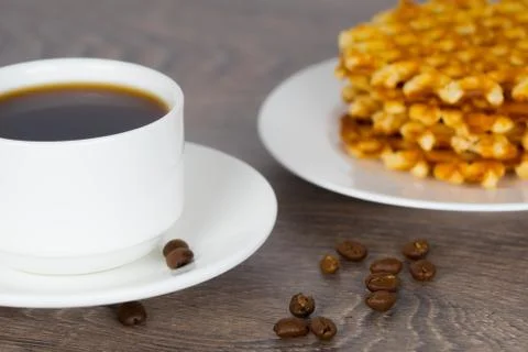 Coffee cup with stack of belgian round waffles on wooden table Stock-Fotos