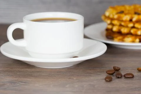 Coffee cup with stack of belgian round waffles on wooden table Stock-Fotos