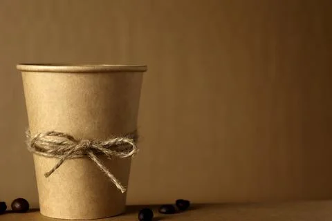 Coffee cup on a table with brown background and coffee beans on the side Stock Photos