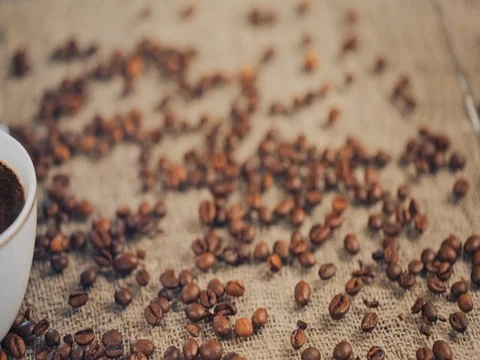 Coffee cup on a  table with coffee beans. Slow motion 스톡 동영상 73670346