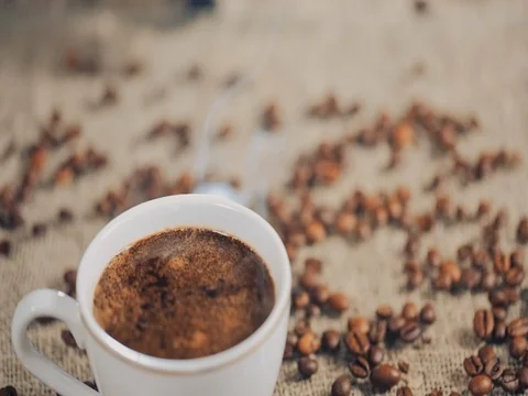 Coffee cup on a  table with coffee beans. Slow motion 스톡 동영상 73670414